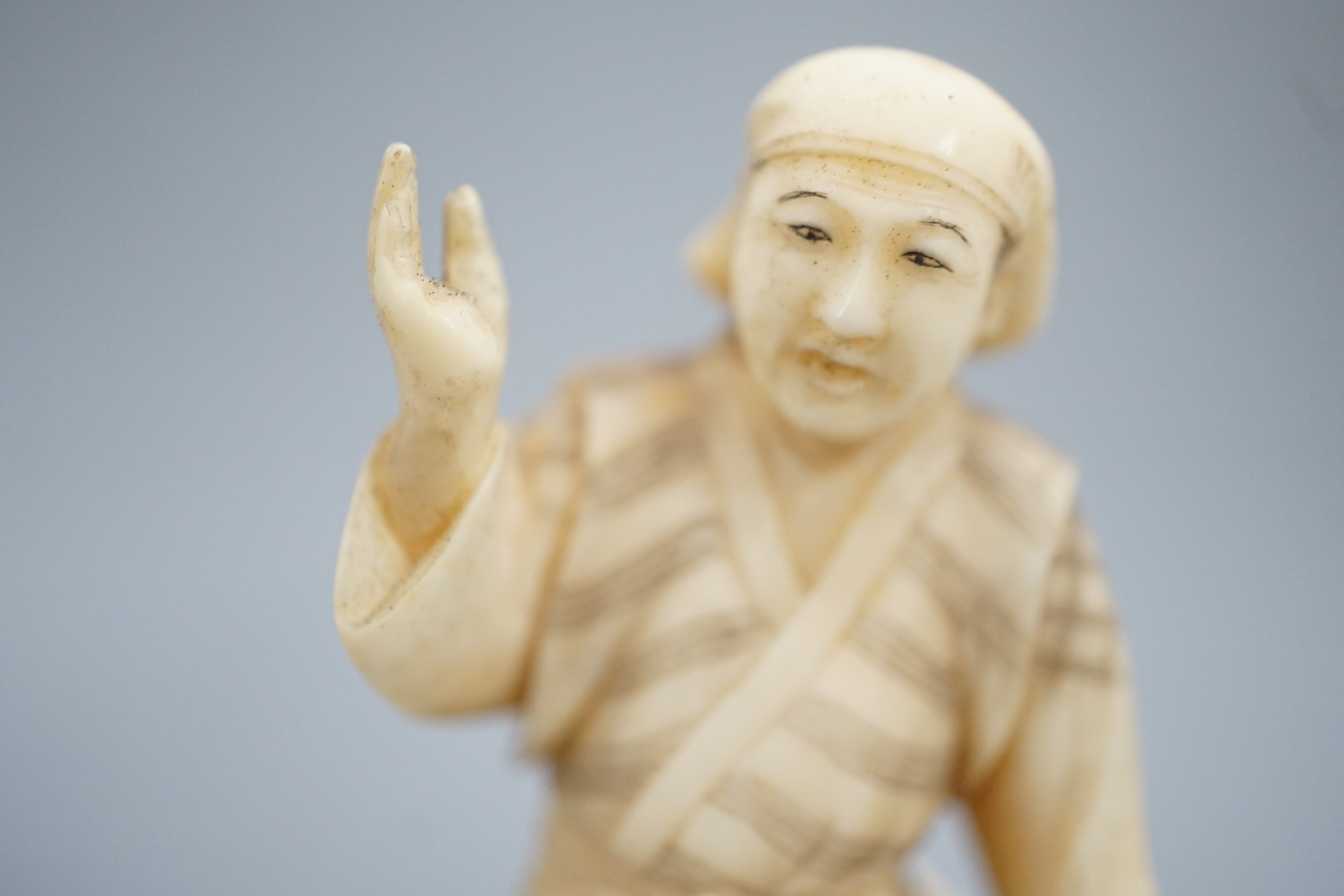 A Japanese ivory okimono of a monkey trainer, signed, Meiji period, 7.7 cm